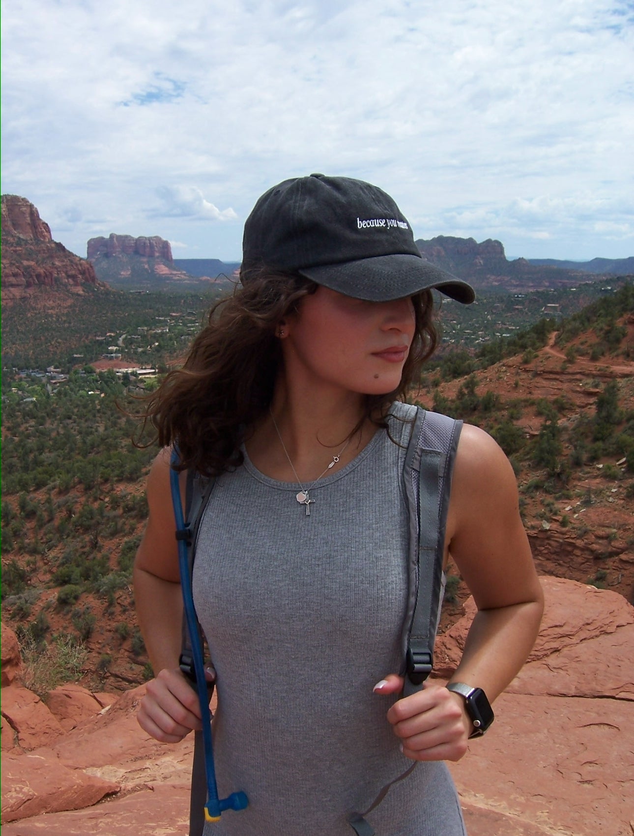 Woman standing on a scenic overlook with mountains in the background